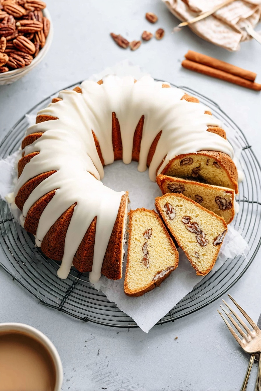 A cake with white frosting and nuts on top.