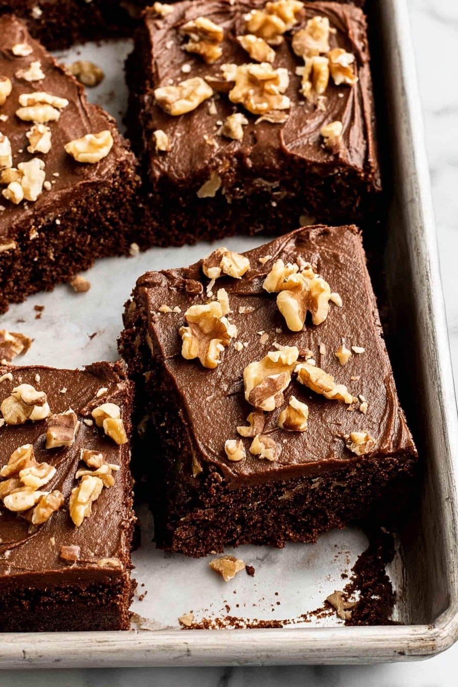 A slice of chocolate cake with nuts on top.