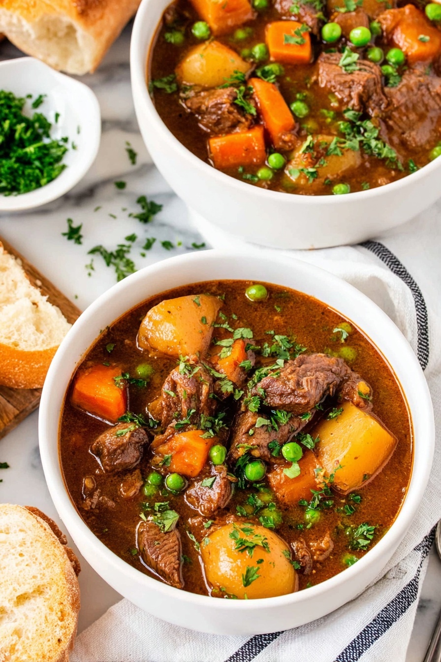 Two bowls of beef stew with peas and potatoes.