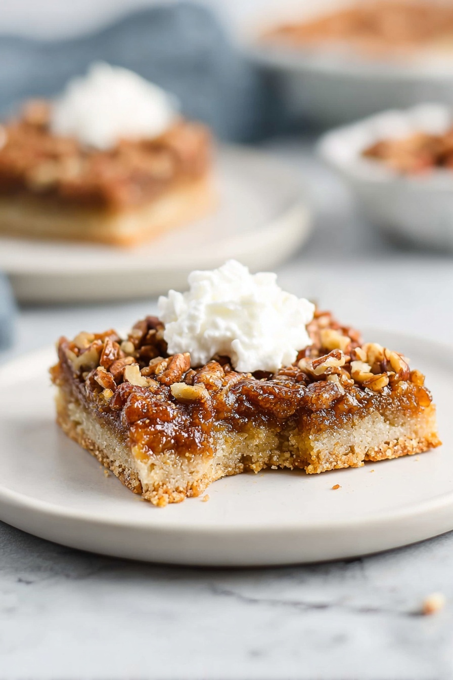 A slice of pecan pie bars with whipped cream on top.