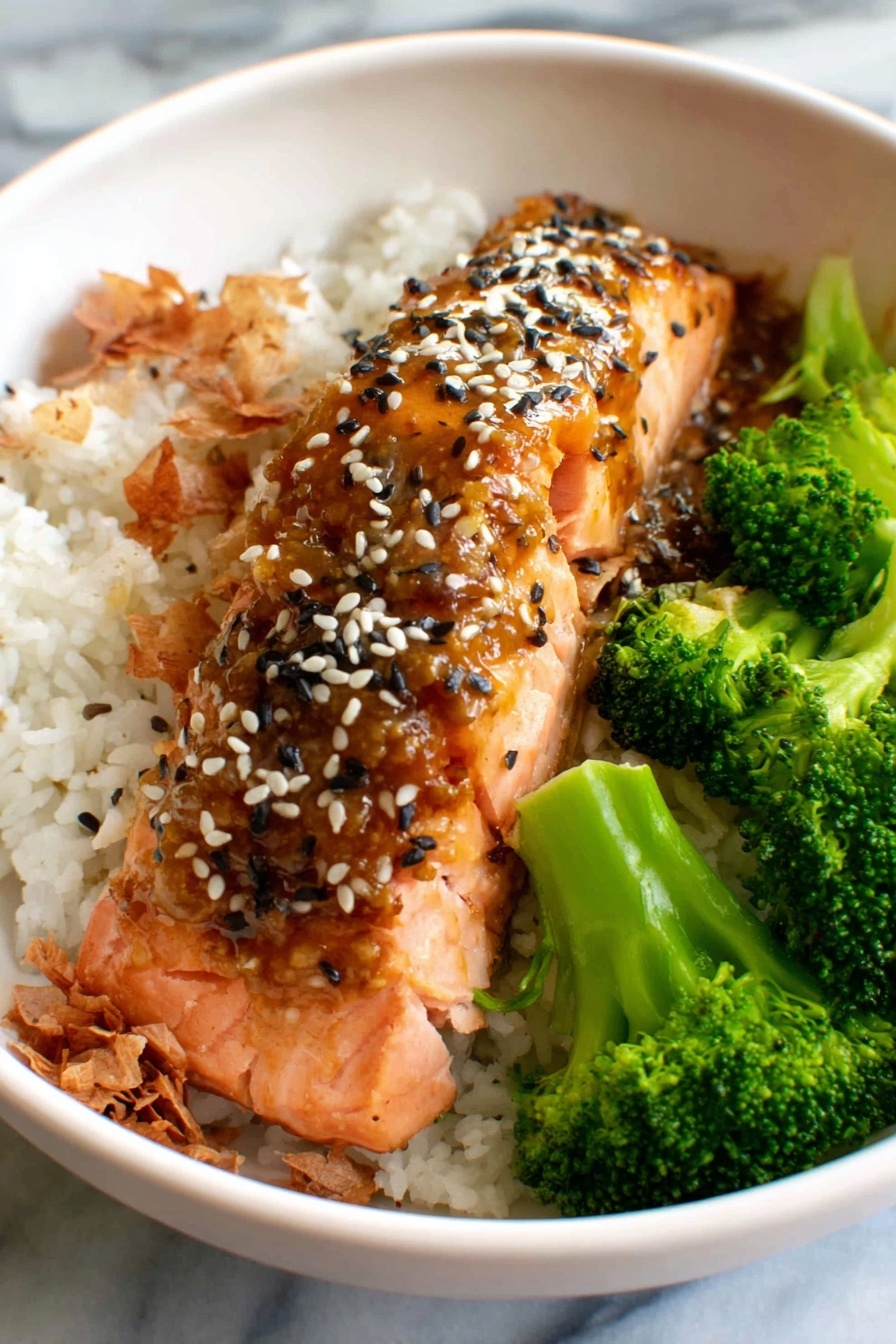 A bowl of food with rice, broccoli, and fish.