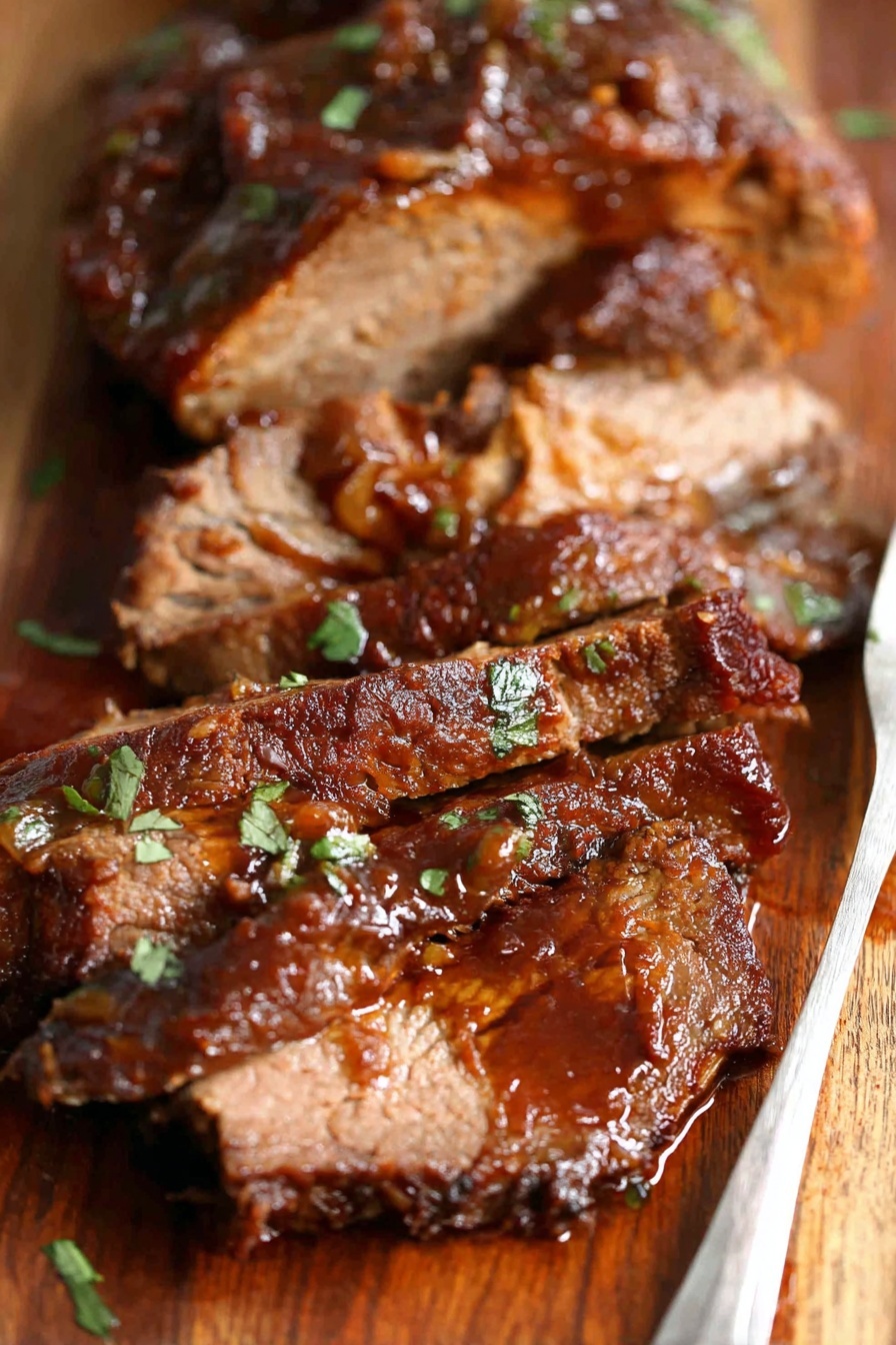 A piece of meat with a wooden spoon on top.