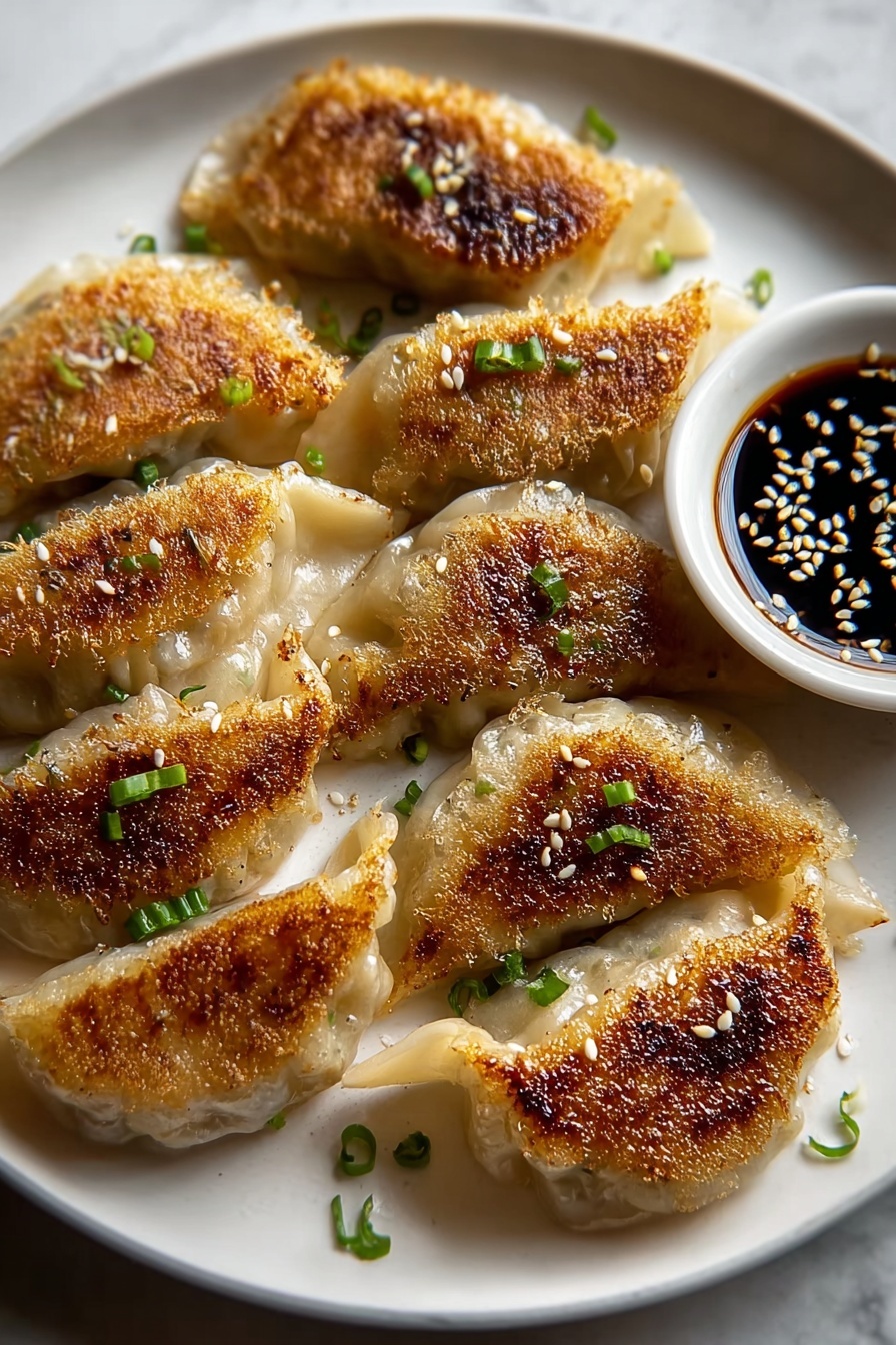 Crispy pan-fried dumplings with a dipping sauce.