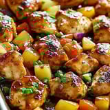 Chicken, pineapple, and onions all roasted together in a pan.