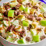 Bowl packed with apples, chocolate, and caramel drizzle.