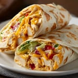 Two wraps on a plate with chicken filling.