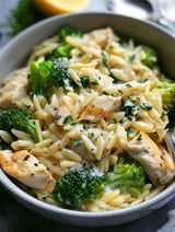 A bowl of chicken and broccoli orzo.