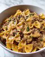 A bowl of creamy Parmesan garlic beef bowtie pasta.