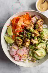 A bowl of food with noodles, vegetables, and meat.