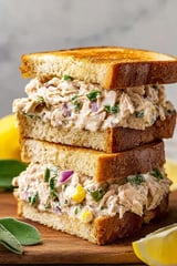 Three stacked tuna melts with onions and peppers.