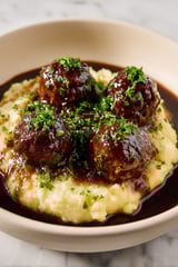 Meatballs in a bowl of gravy.