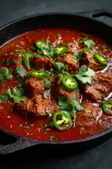 A bowl of chicken with green peppers and onions.