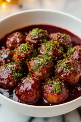 A bowl of meatballs in a red sauce.