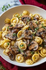 A plate of pasta with mushrooms and cheese.