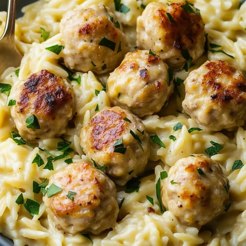 A bowl stuffed with pasta, juicy meatballs, and greens.
