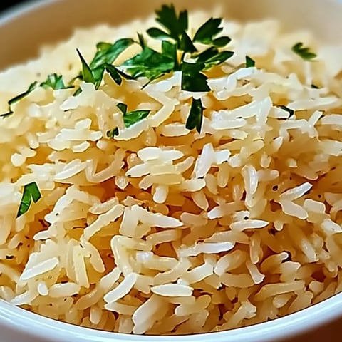 A bowl of rice with green herbs on top.