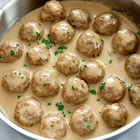 A bowl of meatballs in a creamy sauce.