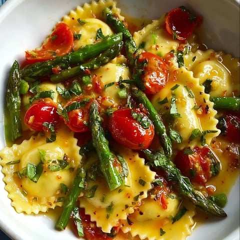 Pasta bowl loaded with tomatoes and asparagus spears.
