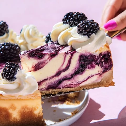 Someone digging into a blueberry cheesecake slice.