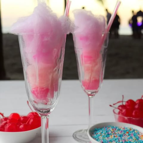 Two glasses filled with pink cotton candy.