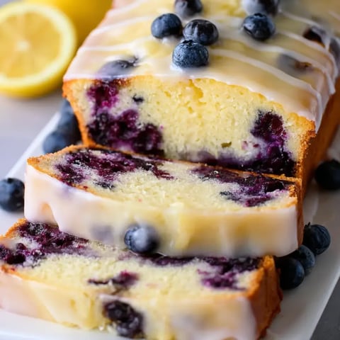 Blueberry-studded loaf with lemon slices on top.