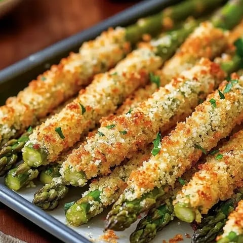 A tray loaded with green asparagus topped with a golden crust.