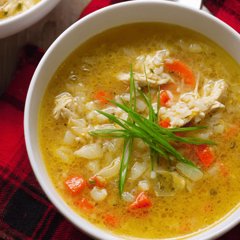 Soup in a bowl topped with something green.
