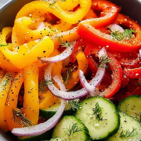 A big bowl filled with chopped cucumbers, peppers, and onions.