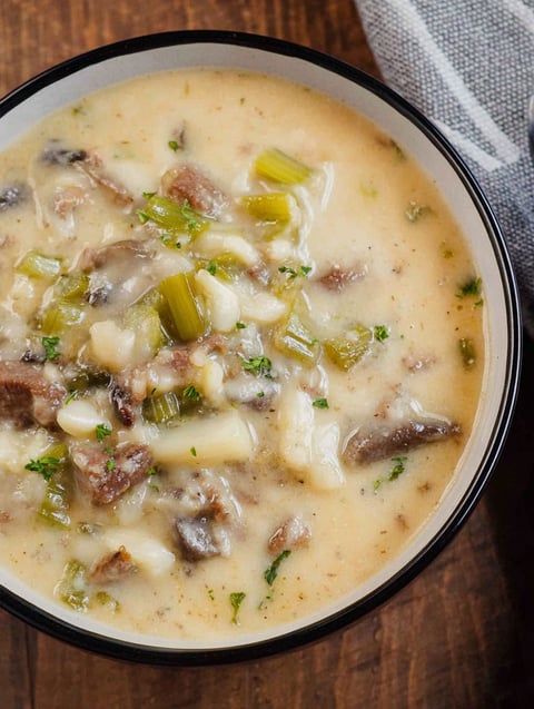 A bowl of soup with meat and vegetables.