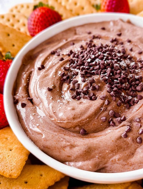 A bowl of brownie batter dip with chocolate chips on top.