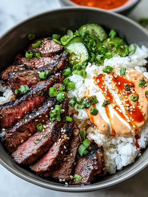 A bowl of food with rice, meat, and vegetables.