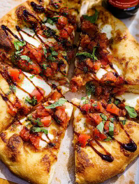 A slice of Bruschetta pizza with tomatoes and basil.