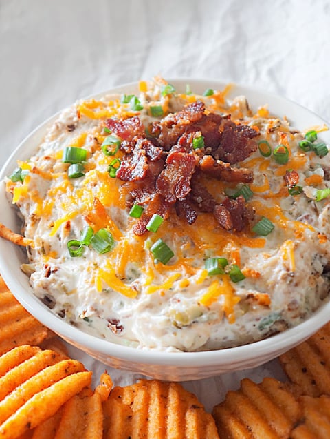 A bowl of loaded baked potato dip.