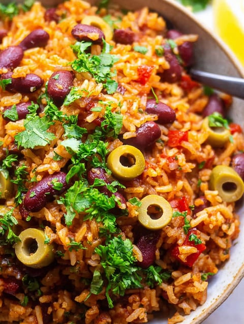 A bowl of rice and beans with green onions.
