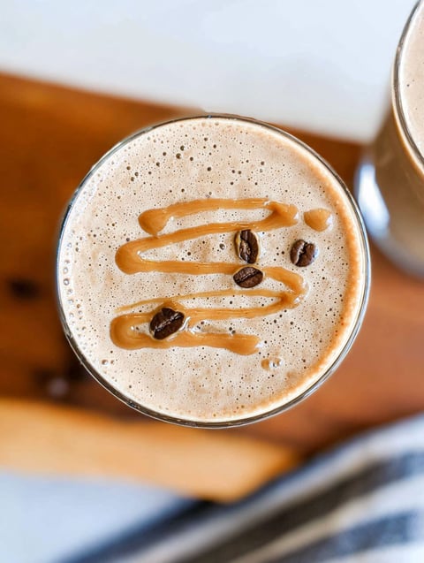 A glass of coffee smoothie with a drizzle of caramel.