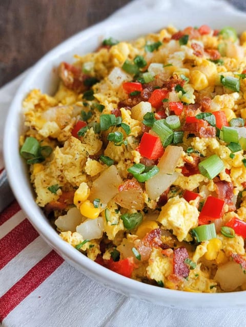 A skillet breakfast scramble with vegetables and bacon.