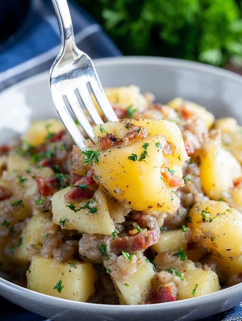 A fork is in a bowl of old-fashioned German potato salad.