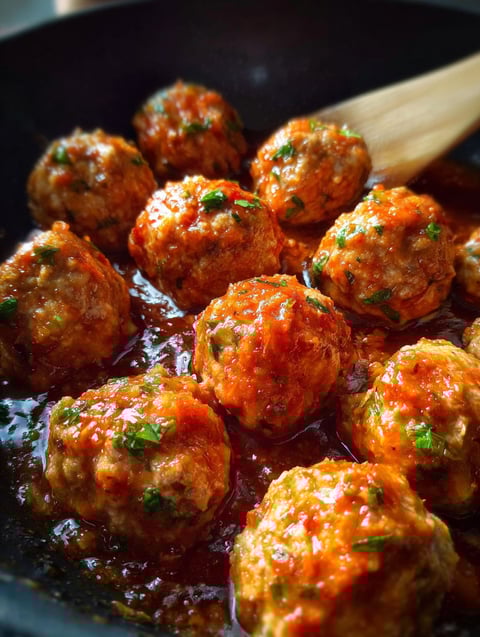 A pan of meatballs in a tomato sauce.
