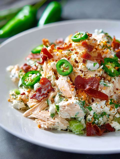 A plate of food with jalapenos and bacon.