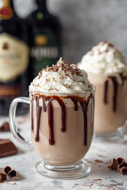 A glass of chocolate milk with whipped cream.