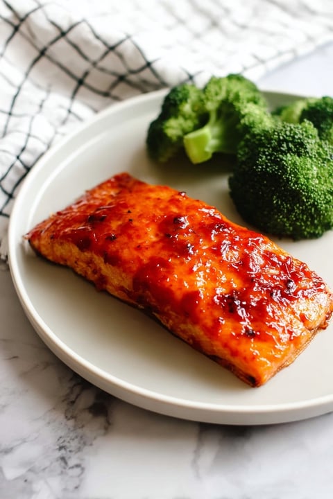 A piece of salmon with a sauce on top.