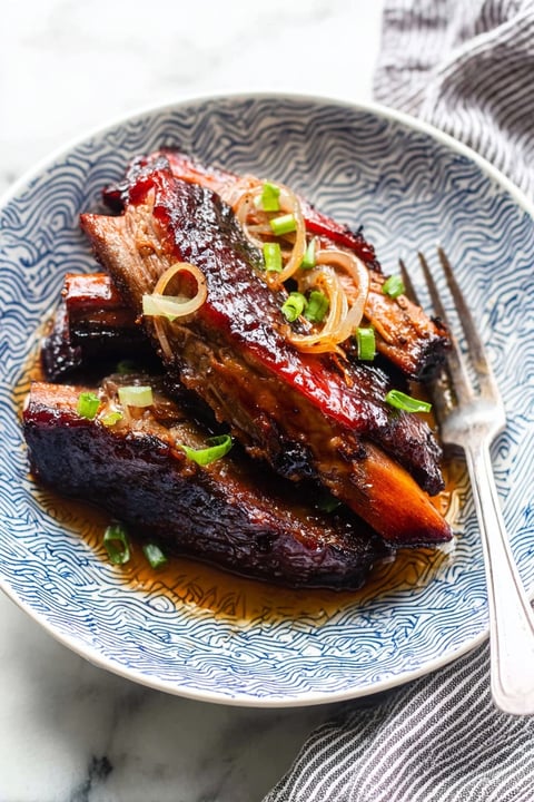 A plate of meat with onions on it.