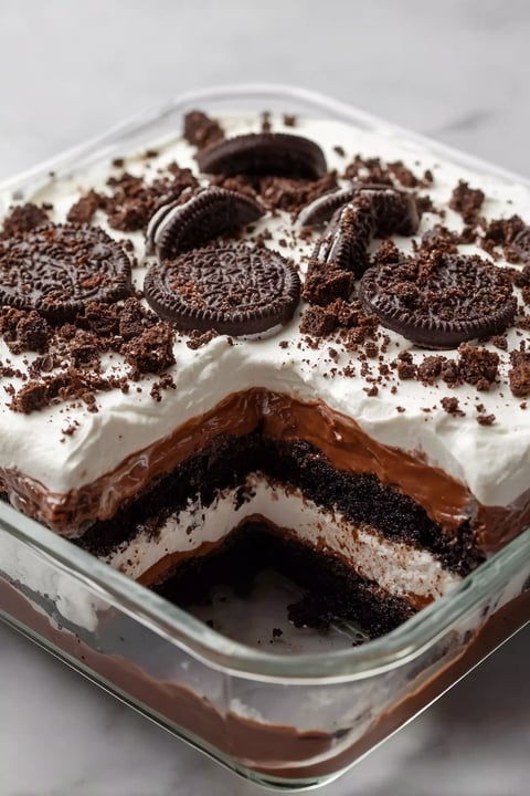 A slice of chocolate cake with Oreo cookies on top.