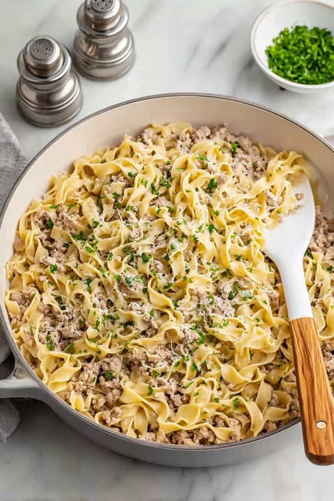 A large bowl of pasta with meat and cheese.