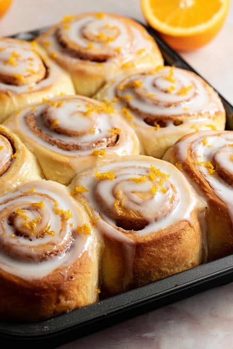 Orange rolls in a pan.