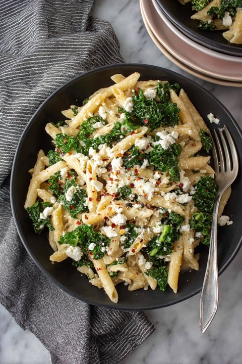 A bowl of pasta with broccoli and cheese.