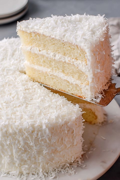 A slice of coconut cake on a plate.