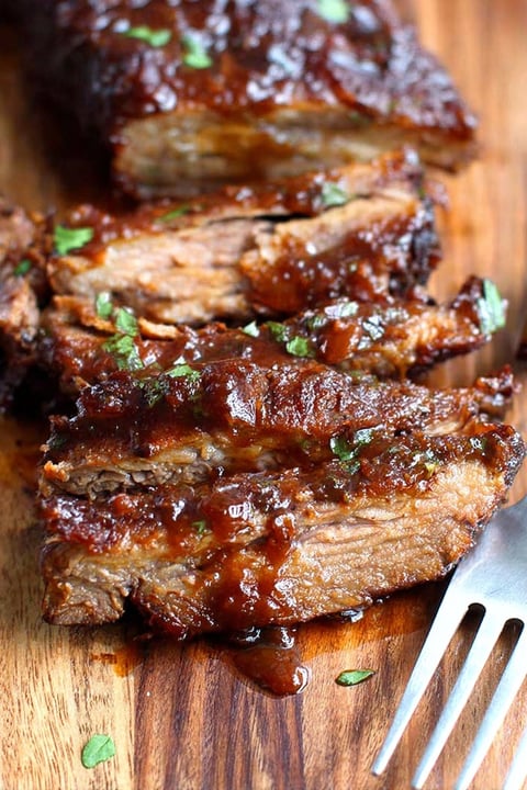 A piece of meat on a wooden cutting board.